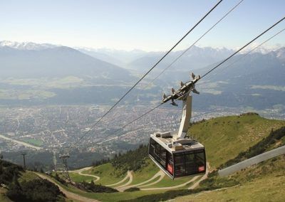 Una funivia che scende da una collina in Tirolo con il teleferico sullo sfondo.