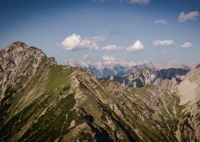 Das Tiroler Gebirge bietet atemberaubende Ausblicke auf die Karwendelgipfel, umgeben von einem strahlend blauen Himmel und flauschigen Wolken.